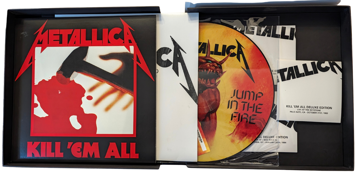 Metallica Kill 'Em All Deluxe Edition vinyl record set shown open, including the black outer box with printed cover art, the record sleeve, a gold vinyl disc with red/orange artwork, a printed insert, and a small card.